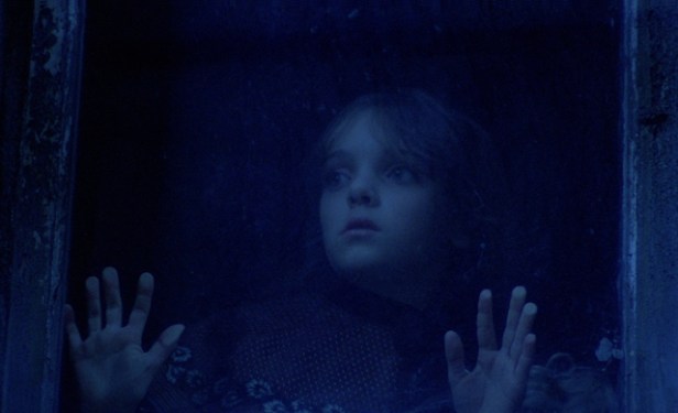 Photo petite fille blonde derrière la fenêtre